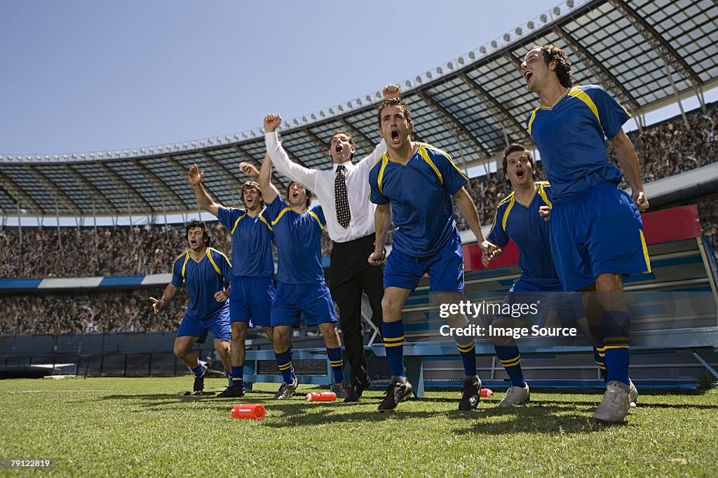 Football manager and footballers celebrating