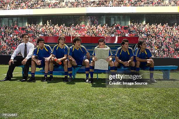 footballer reading a newspaper - paper football stockfoto's en -beelden