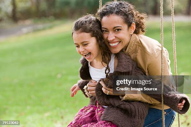 mother and daughter on swing - latin american and hispanic ethnicity 個照片及圖片檔