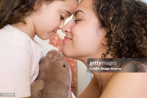 mother and daughter rubbing noses - nuzzling stockfoto's en -beelden