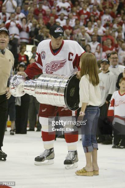 Captain Steve Yzerman of the Detroit Red Wings holds the Stanley Cup with his daughter Isabella after eliminating the Carolina Hurricanes during game...