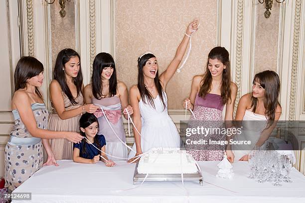 girls pulling ribbons from cake - quinceanera party stock pictures, royalty-free photos & images