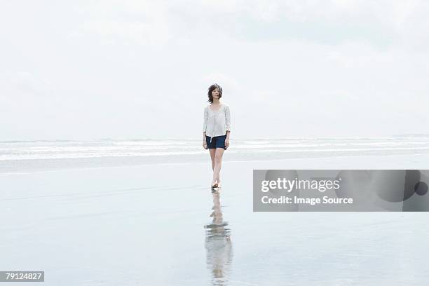 mulher caminhando até o mar - wading - fotografias e filmes do acervo