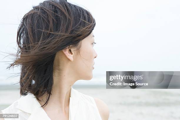 young woman looking towards sea - tousled hair stock pictures, royalty-free photos & images