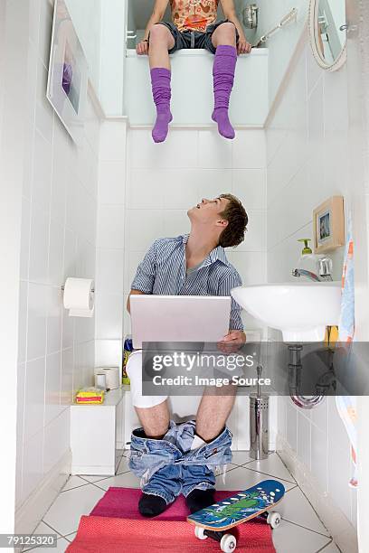 woman sitting above man on toilet - weird roommate stock pictures, royalty-free photos & images