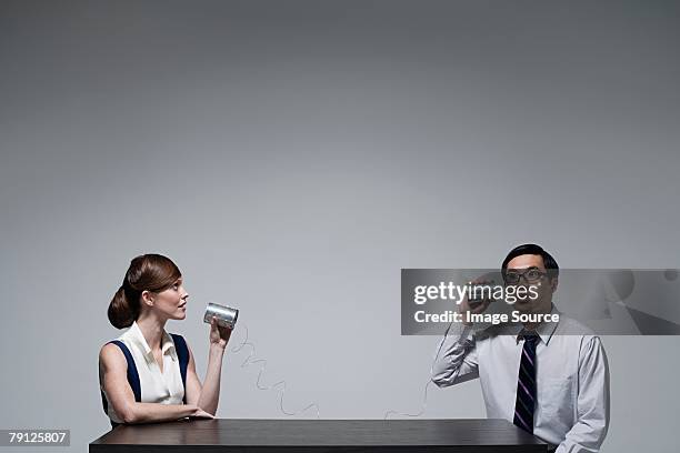 businesspeople using a tin can telephone - listening tin can stock pictures, royalty-free photos & images