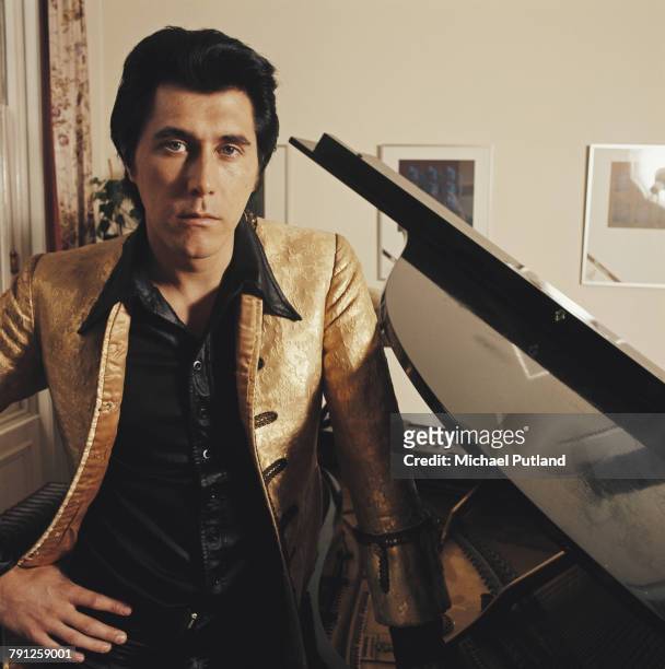 English musician, singer and songwriter Bryan Ferry of Roxy Music, pictured wearing a gold jacket at home in London circa 1972.