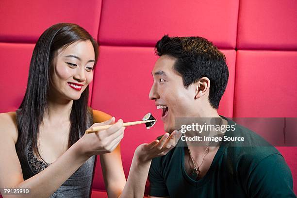 femme nourrir boyfriend - bar à sushis photos et images de collection