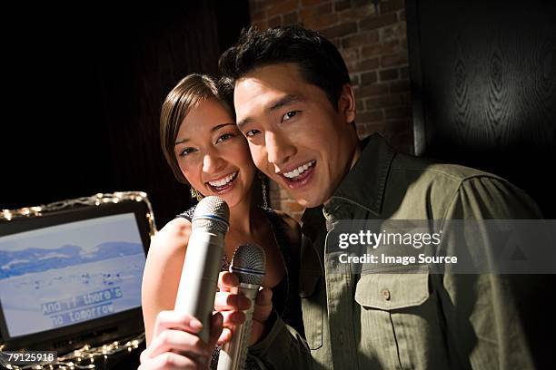 couple singing karaoke - karaoke stock pictures, royalty-free photos & images