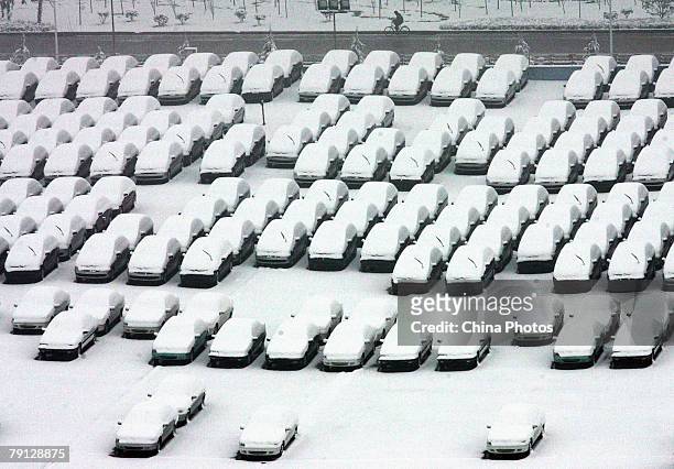The elevated view of snow-covered cars at an automobile market is seen after the second snowfall of this week, the heaviest snowfalls that have been...