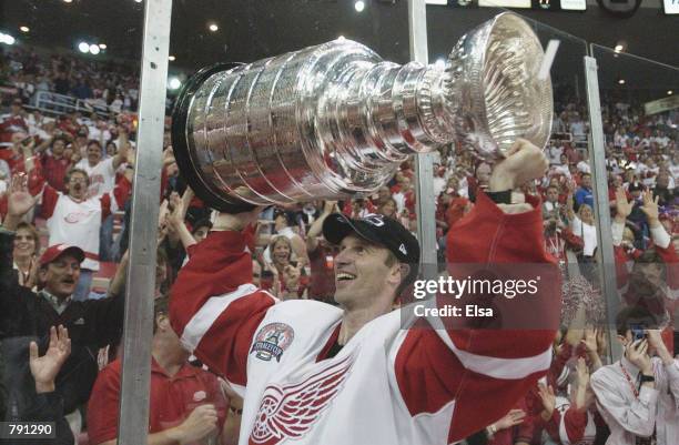 Dominik Hasek of the Detroit Red Wings raises the Stanley Cup after eliminating the Carolina Hurricanes during game five of the NHL Stanley Cup...