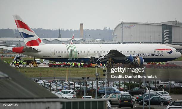 Emergency crew install a low loader under the body of the Boeing 777 plane which crashed on Thursday, in preparation to move it from Heathrow's south...