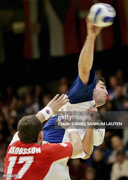 Nikola Karabatic of France scores a goal as Iceland's Sverre Jakobsson tries to prevent the attempt during their group D match 20 January 2008 in the...