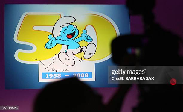 Camerawoman takes pictures of a smurf-video on display during an event 21 January 2008 in Berlin to celebrate the smurfs' 50th anniversary. The...