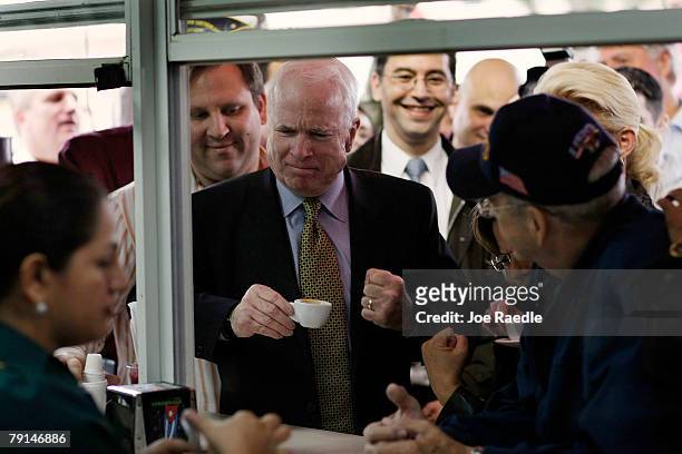 United States Presidential hopeful Sen. John McCain pumps his fist after taking a sip of Cuban expresso during a campaign visit to the Versailles...