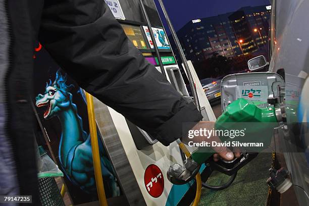 An attendant fills up a car at a gasoline station January 21, 2008 in Raanana in central Israel. Israel announced plans to promote electric cars on a...