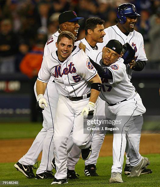 New York Mets batter David Wright, front, celebrates with teammate Jose Lima after Wright knocked in the winning run, 7-6, in the ninth inning...