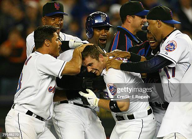 New York Mets batter David Wright celebrates with teammates after he connected for a single to knock in the winning run in the ninth inning against...