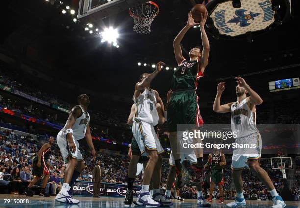 Yi Jianlian of the Milwaukee Bucks goes up for a shot between Paja Stojakovic and Tyson Chandler of the New Orleans Hornets January 21, 2008 at the...