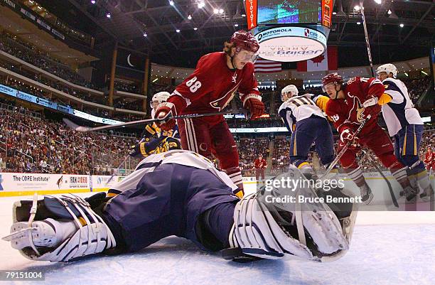 Goaltender Jocelyn Thibault of the Buffalo Sabres defends against Peter Mueller and Shane Doan of the Phoenix Coyotes on January 21, 2008 at the...