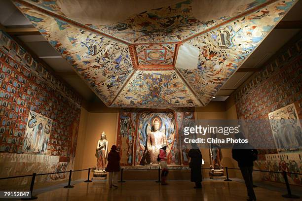 Visitors view replica of parts of the Mogao Cave during the Dunhuang Art Exhibition at the National Art Museum of China on January 21, 2008 in...