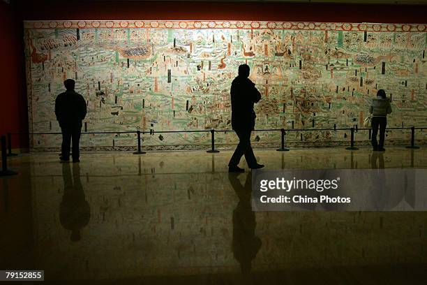 Visitors view a replica of a 13-meter-long fresco from the Mogao Cave during the Dunhuang Art Exhibition at the National Art Museum of China on...