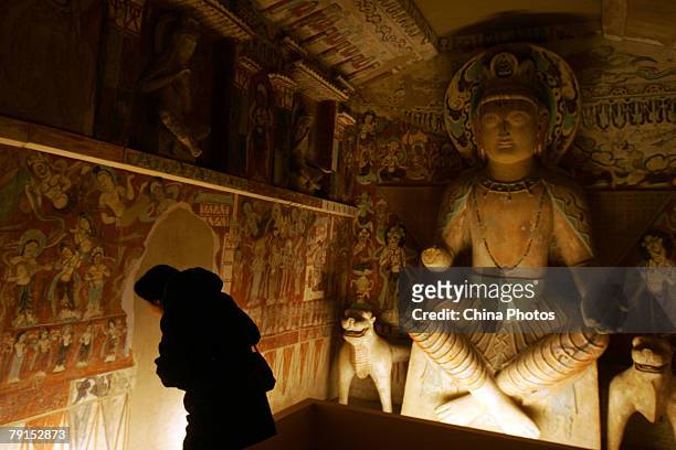 Visitor views replica of parts of the Mogao Cave during the Dunhuang Art Exhibition at the National Art Museum of China on January 21, 2008 in...