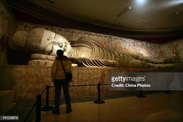 Visitor views a replica of Buddhist statue from the Mogao Cave during the Dunhuang Art Exhibition at the National Art Museum of China on January 21,...
