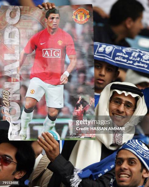 Saudi fans hold a poster of Manchester United player Cristiano Ronaldo prior to a football match between Manchester United and Saudi club al-Hilal at...