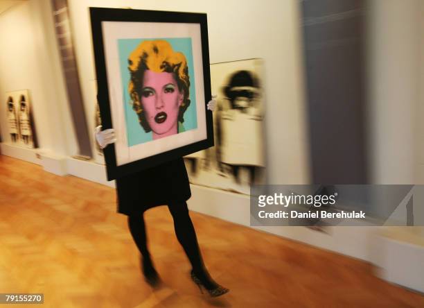 In this photo illustration, Banksy's Kate Moss screenprint is held by a Bonham's employee during the photocall viewing for the World's First Uban Art...