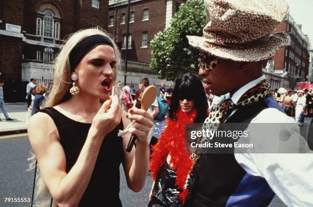 Marcher applying lip-gloss during Lesbian and Gay Pride, Whitehall, London, 18th June 1994.