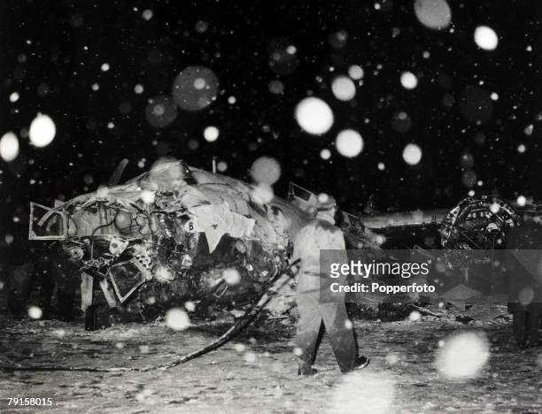 Rescue workers with wreckage of the B.E.A. Elizabethan airliner G-ALZU 'Lord Burghley' after the crash at Munich in which 23 people died, including 8...