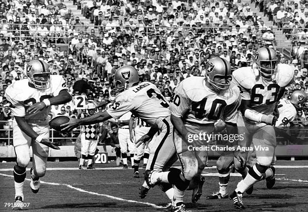 Oakland Raiders quarterback Daryle Lamonia hands off to funning back Charles Smith as running back Pete Banaszak and guard Gene Upshaw lead the way...
