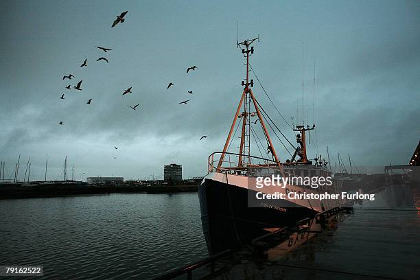 Solitary British fishing trawler sits in it's berth at Grimsby Fish Docks in northen England as the British fishing industry continues to strive to...