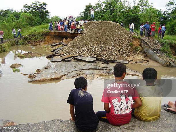 Local residents look at the remains of the road over the Ichilo river 22 January in the locality of Poza Azul, some 165km north of Santa Cruz. The...