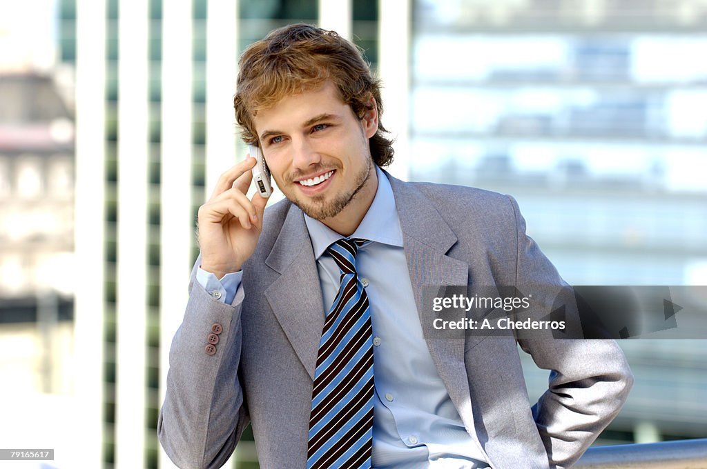 Businessman using mobile phone, smiling