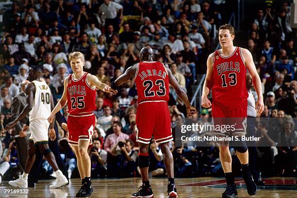 Michael Jordan of the Chicago Bulls high fives teammates Steve Kerr and Luc Longley against the Seattle SuperSonics in Game Three of the 1996 NBA...