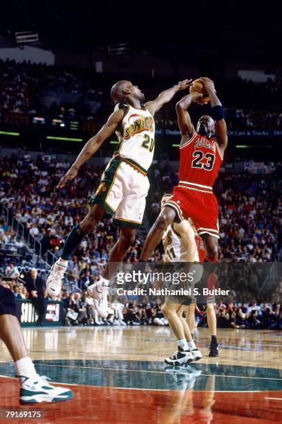 Michael Jordan of the Chicago Bulls shoots a jump shot over Gary Payton of the Seattle SuperSonics in Game Three of the 1996 NBA Finals at Key Arena...