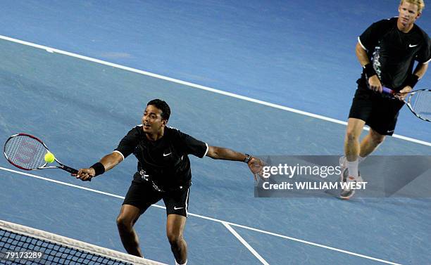 Indian tennis player Mahesh Bhupathi is watched by Bahamian partner Mark Knowles as he plays a stroke during their mens doubles match against US pair...