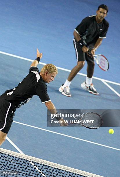 Indian tennis player Mahesh Bhupathi watches as Bahamian partner Mark Knowles plays a stroke during their mens doubles match against US pair Bob and...