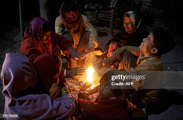 Indian pavement dwellers warm themselves around a fire in Siliguri, 23 January 2008, as the temperature drops in the region. At least 47 people have...