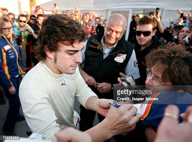 Fernando Alonso of Spain and team Renault signs autographs to fans after leaving his team's garage during Formula one testing at the Ricardo Tormo...