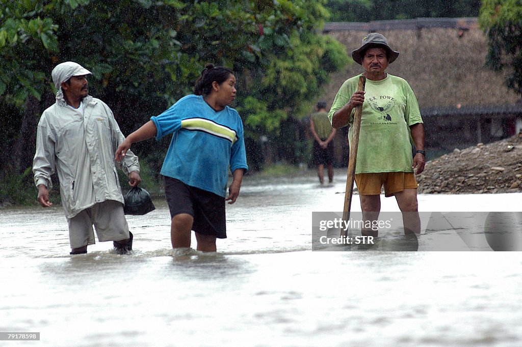 Local residents attempt to cross a flood