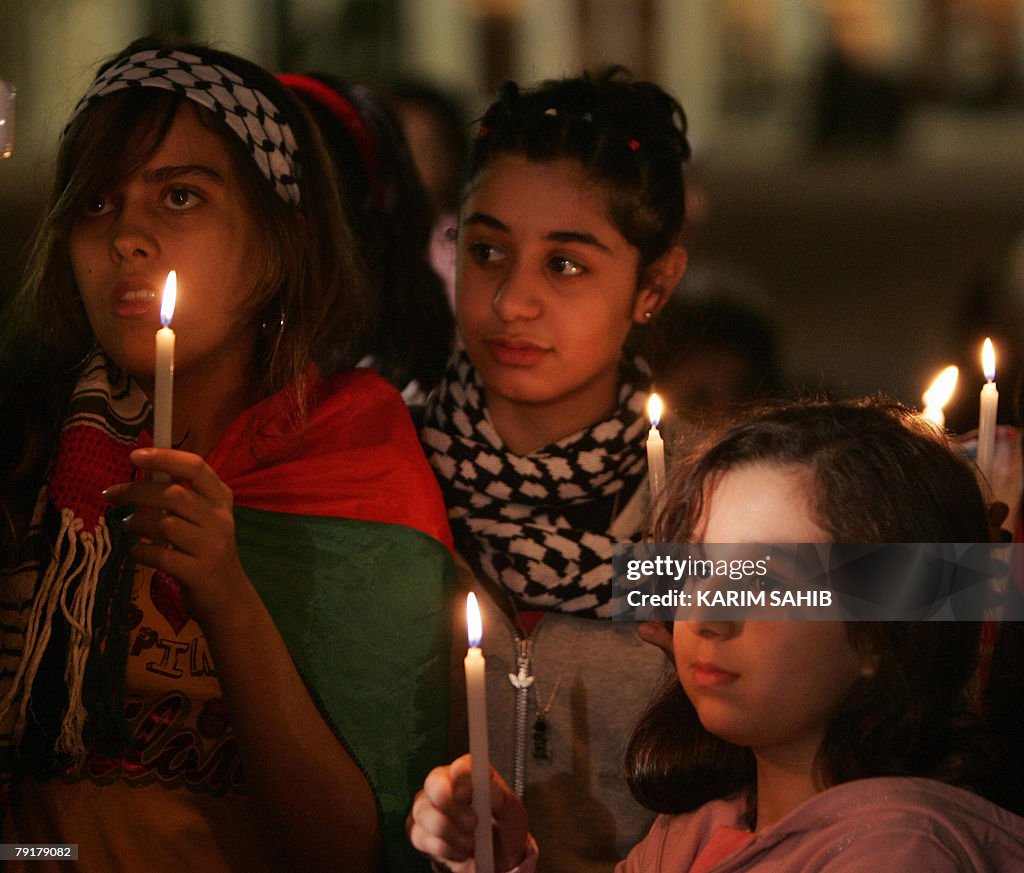 Palestinian girls hold up candles during