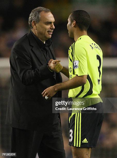 Avram Grant of Chelsea congratulates Ashley Cole after victory in the Carling Cup Semi Final Second Leg match between Everton and Chelsea at Goodison...