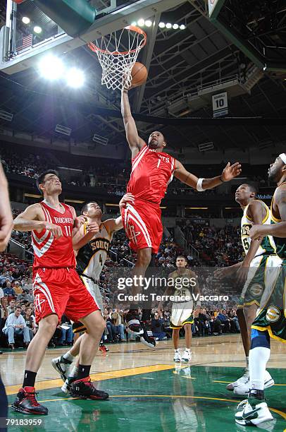 Tracy McGrady of the Houston Rockets goes to the basket between the defense of Nick Collison and Kevin Durant of the Seattle SuperSonics on January...