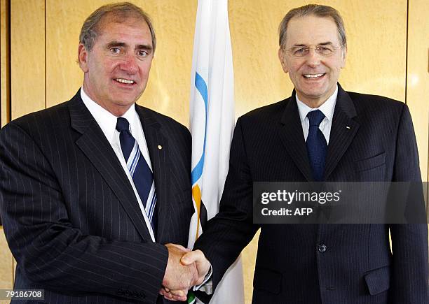 Chief of the World Anti-Doping Agency, former Australian finance minister John Fahey shakes hands with International Olympic Committee president...