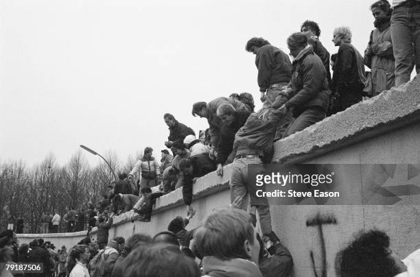 East Berliners climb onto the Berlin Wall to celebrate the effective end of the city's partition, 31st December 1989.