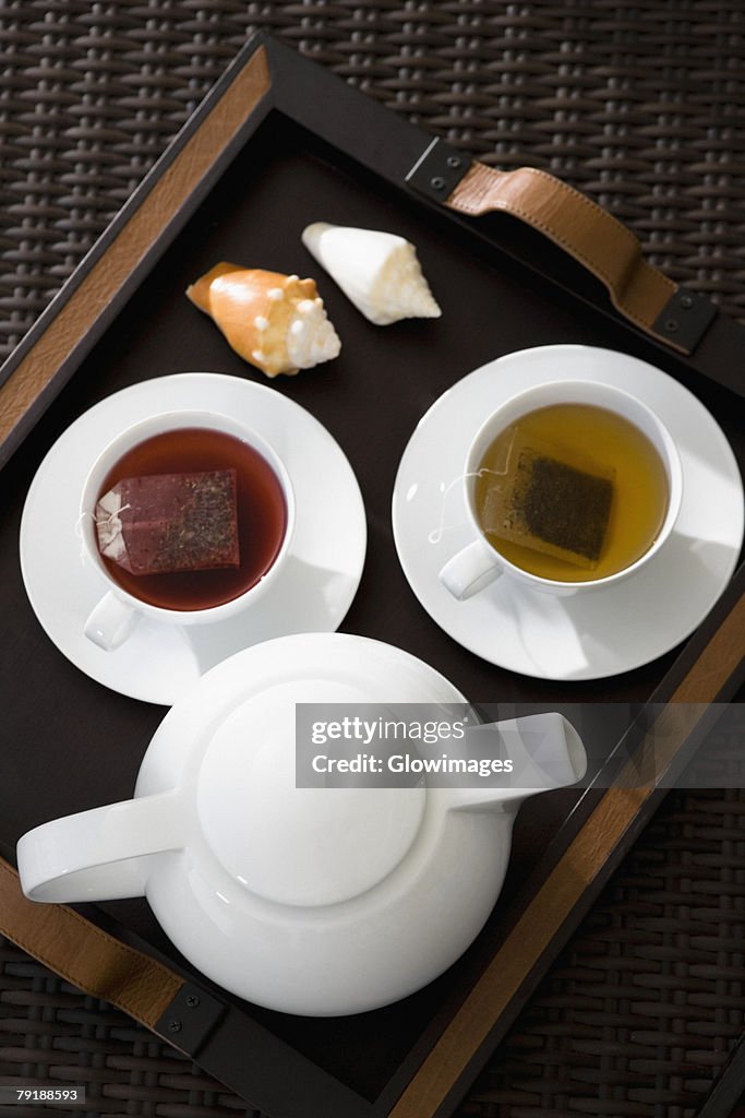 High angle view of cups of herbal tea with a teapot on a serving tray