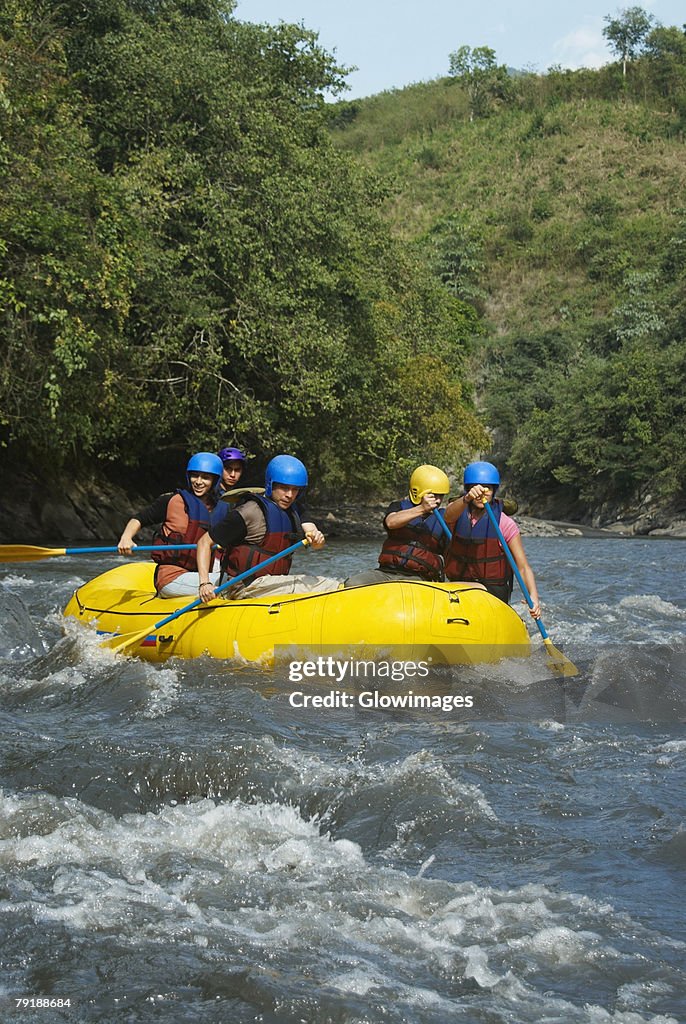 Five people rafting in a river